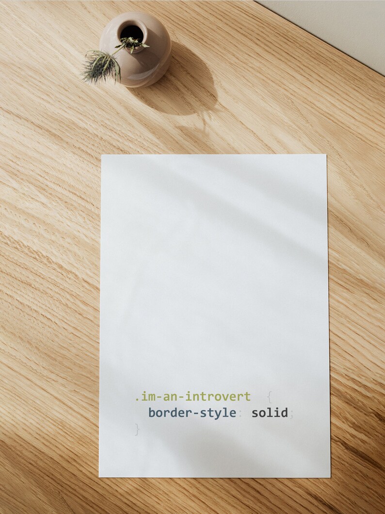 K&ouml;nnte beinhalten: Ein wei&szlig;es Blatt Papier mit dem Text ".im-an-introvert { border-style: solid; }" darauf. Das Papier liegt auf einer hellbraunen Holzoberfl&auml;che.