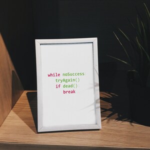 May include: A white framed picture with a motivational quote written in code: "while noSuccess tryAgain() if dead() break"