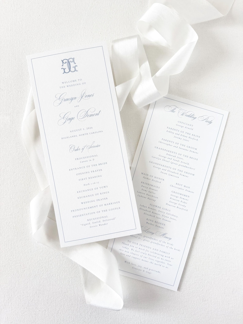 May include: Two white wedding program cards with blue text and a blue monogram at the top. The left card lists the order of service for Gracyn Jones and Gage Dement on August 3, 2024. The right card lists the wedding party. A white ribbon is draped.