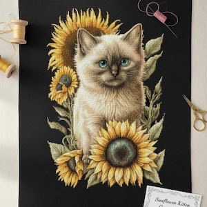 May include: Cross-stitch of a kitten with blue eyes surrounded by sunflowers on a black background. The cross-stitch design includes a variety of yellow and green hues. The text on the card reads "Sunflower Kitten Cross Stitch".