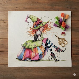 May include: Cross-stitch of a seated witch with red hair, wearing a green hat adorned with roses and a colorful dress. Accessories include embroidery floss, scissors, and a mushroom pin. The artwork is on a white fabric.