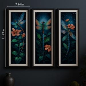 May include: Three framed art prints featuring dragonfly illustrations. Each print showcases a dragonfly with colorful wings, flowers, and foliage against a dark blue background. The frames are black, and the prints measure 21.29 inches tall and 7.14 inches wide.