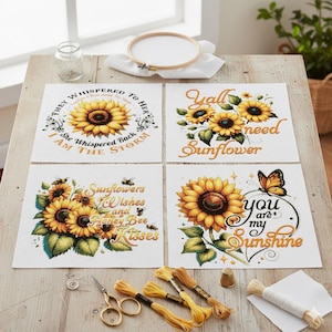 Puede incluir: Cuatro patrones cuadrados de punto de cruz con diseños de girasoles y citas inspiradoras. Los patrones incluyen texto como "Eres mi sol". También se ven suministros de bordado.