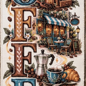 May include: A vertical cross-stitch embroidery on white fabric featuring the word COFFEE in large, decorative letters. The design includes illustrations of coffee cups, a grinder, a moka pot, a cafe storefront, croissants, and muffins.