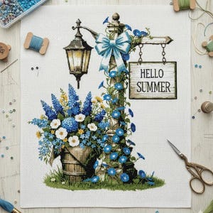 Puede incluir: Diseño de punto de cruz que representa un letrero de calle rústico con una farola y un cubo de madera rebosante de flores azules y blancas. Un letrero dice "HELLO SUMMER". Un lazo azul y enredaderas.