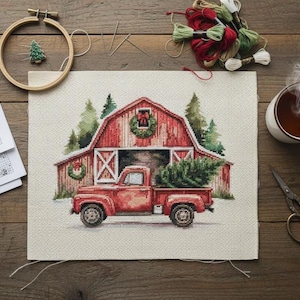 May include: A cross-stitch project depicting a red pickup truck carrying a Christmas tree in front of a red barn. The scene is surrounded by embroidery supplies, a cup of tea, and a wooden embroidery hoop. The color palette includes red, green, and brown.