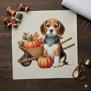 May include: Cross-stitch design featuring a beagle wearing a blue bandana, sitting next to a wooden wheelbarrow filled with pumpkins and autumn leaves. The beagle is brown, black, and white. The scene evokes a fall harvest theme.