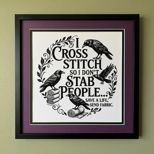 May include: A framed cross-stitch artwork featuring black ink illustrations of three crows and floral vines on white fabric. The text reads: I CROSS STITCH SO I DON'T STAB PEOPLE... SAVE A LIFE, SEND FABRIC. The piece is in a black frame with a purple mat.