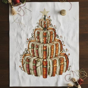 May include: A cross-stitch design of a Christmas tree made of stacked books and pumpkins, topped with a star. The design is on white fabric, with spools of thread, needles, and scissors around it.