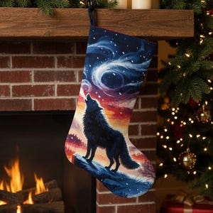 May include: Christmas stocking with a wolf howling at the moon design. The stocking features a dark blue background with a colorful sunset and a silhouette of a wolf. The stocking is hanging from a wooden mantel.