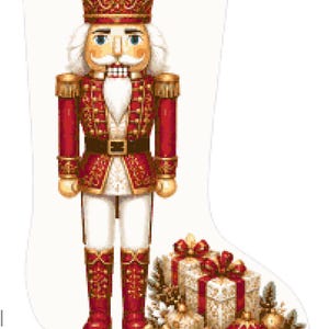 May include: A white Christmas stocking featuring a printed design of a nutcracker soldier in a red and gold uniform with a matching crown. At the base of the nutcracker are several wrapped gift boxes, gold and red ornaments, and pine branches.