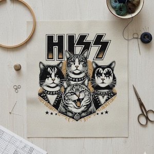 May include: Cross-stitch design featuring four cats in rock band makeup, with the word "HISS" in a bold font. The cats are in black and white, with star accents. The design is on a beige fabric.