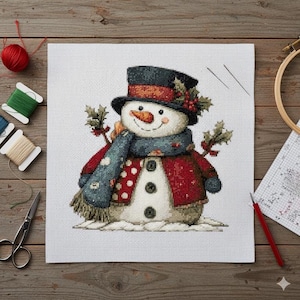 May include: A cross-stitch snowman with a black top hat, red jacket, and blue scarf. The snowman has a carrot nose and is decorated with holly. Crafting supplies, including thread, scissors, and a needle, are visible.