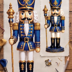 May include: Two cross-stitch patterns of a nutcracker on fabric, featuring a blue and gold uniform, a tall hat, and a staff. The scene includes embroidery floss in blue and gold, a metal thimble, a needle, a pencil, and ornate scissors.