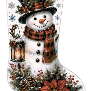 Puede incluir: Un calcetín navideño blanco con el diseño de un muñeco de nieve que lleva un sombrero de copa negro y una bufanda de cuadros rojos y negros. El muñeco sostiene un farol, rodeado de copos de nieve azules, ramas de pino, bayas y una flor de pascua.