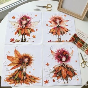 May include: Four cross-stitch patterns featuring whimsical fairy designs with autumn leaf dresses and hair. The fairies have delicate wings and are surrounded by falling leaves. The set includes embroidery floss, scissors, and needles.