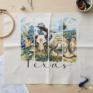 Puede incluir: Un proyecto de punto de cruz con temática de Texas. El diseño incluye imágenes de flores azules, una calavera de cuernos largos, pájaros y botas de vaquero. La palabra "Texas" está escrita en cursiva debajo. La tela es blanca.