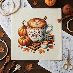 May include: Cross-stitch design featuring a fall theme. A large mug of chai latte with a heart design, pumpkins, cinnamon sticks, and the text "Chai Pumpkin & Everything Nice" are displayed. A small sign reads "Pumpkin Spice".