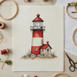 May include: A cross-stitch project featuring a red and white lighthouse with a small attached building. The lighthouse is on a beige background, surrounded by embroidery supplies like thread spools, hoops, and scissors. The scene is set on a light wooden surface.