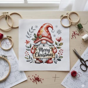Könnte beinhalten: Ein Kreuzstich-Projekt mit einem Weihnachtszwerg, der ein Schild mit der Aufschrift "Merry Christmas" hält. Der Zwerg trägt einen roten Hut und hält ein Holzschild. Stickrahmen, Faden und andere Bastelmaterialien umgeben das Bild.