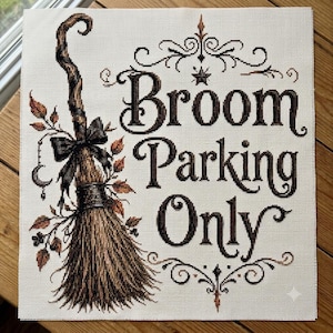 Puede incluir: Un bordado de punto de cruz sobre tela blanca que muestra una escoba marrón con un lazo negro y hojas de otoño. El texto Broom Parking Only aparece en letras decorativas de color marrón oscuro, rodeado de adornos negros y una estrella.