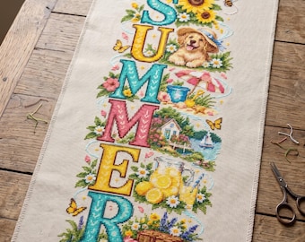 May include: A rectangular beige fabric piece featuring a vertical cross-stitch design spelling SUMMER. Each letter incorporates seasonal imagery including a puppy, a beach scene, a cottage, lemons, and a picnic basket, surrounded by flowers and butterflies.