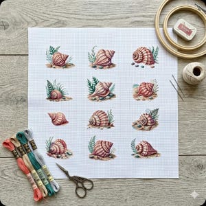 Puede incluir: Un proyecto de punto de cruz con doce diseños detallados de conchas marinas en tonos rosa, marrón y crema, cada uno con follaje verde. El proyecto incluye hilo de bordar de varios colores, tijeras, una aguja y un bastidor de bordado de madera.
