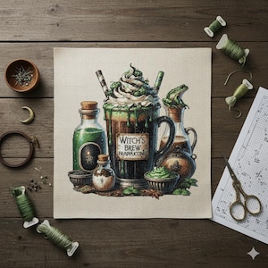 May include: A cross-stitch design featuring a "Witch's Brew Frappuccino" with green accents, whipped cream, and a frog on a bottle. The design includes potion bottles, bowls, and sewing supplies like thread and scissors, set on a wooden surface.