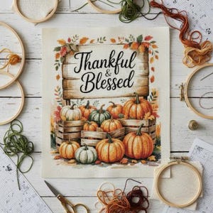 May include: A cross-stitch design featuring pumpkins in various shades of orange and green, arranged in wooden crates. The design includes the text "Thankful & Blessed" and is surrounded by fall foliage. Embroidery hoops, thread, and scissors are arranged around the design.