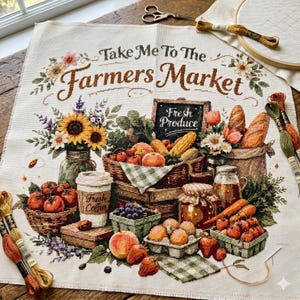Op de afbeelding: Kruissteektextiel met een thema van de boerenmarkt. Het ontwerp toont manden met producten, zonnebloemen en de tekst "Take Me To The Farmers Market". Een kopje koffie en een schoolbord met de tekst "Fresh Produce" zijn ook inbegrepen.