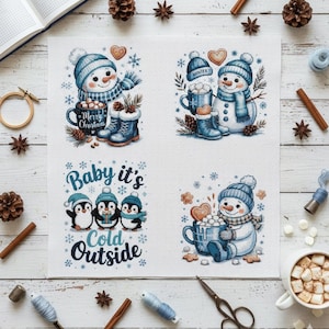 May include: Four cross-stitch designs featuring winter themes. Snowmen in blue hats and scarves with mugs of hot chocolate and boots. One design shows penguins with the text "Baby it's Cold Outside".