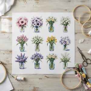 May include: A cross-stitch design showing twelve floral bouquets in glass jars. The flowers include pink anemones, purple crocus, yellow tulips, and white daisies. Embroidery hoops, scissors, and thread spools are arranged around the pattern.