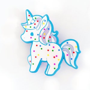 May include: A blue and white unicorn figurine with colorful sprinkles. The unicorn has a blue mane and tail.