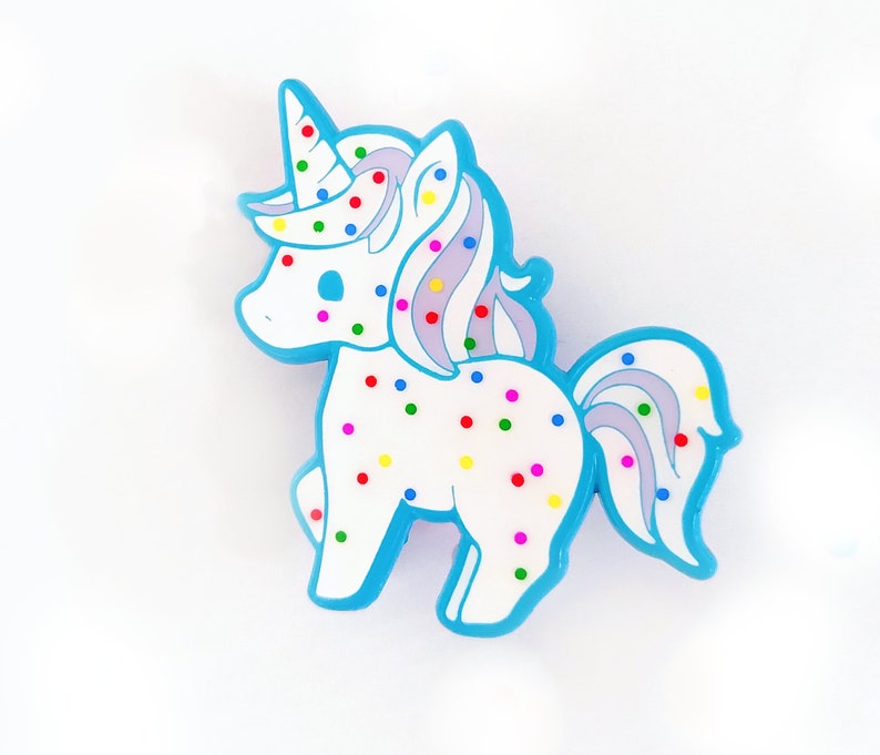 May include: A blue and white unicorn figurine with colorful sprinkles. The unicorn has a blue mane and tail.