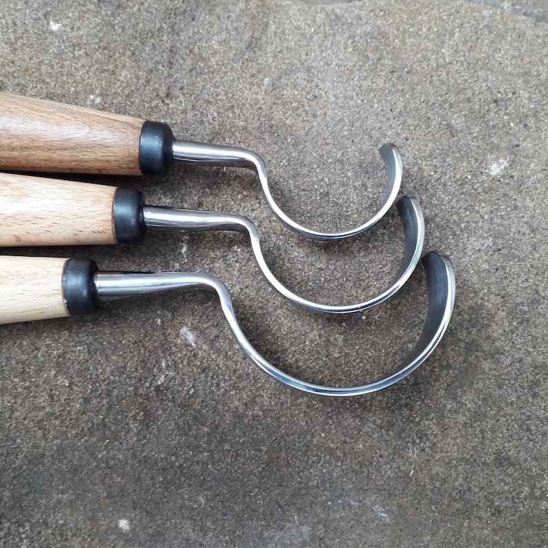 May include: Three wood-handled carving tools with curved metal blades. The tools are arranged in a row, with the largest blade at the bottom and the smallest blade at the top.