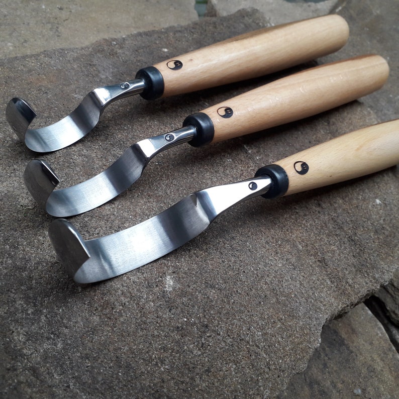 May include: Three wood carving tools with curved blades and wooden handles. Each handle has a black and white yin yang symbol.