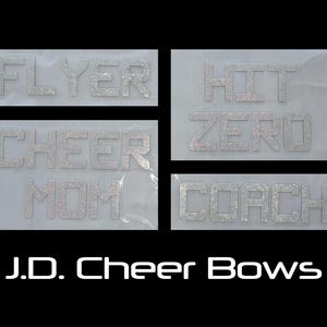 May include: Four rhinestone text designs on a black background. The text includes "FLYER", "HIT ZERO", "CHEER MOM", and "COACH". The brand name "J.D. Cheer Bows" is displayed at the bottom in white.