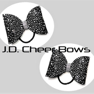 May include: Two black cheer bows with silver rhinestones and elastic hair ties.  J.D. Cheer Bows.