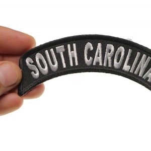 May include: Black and white embroidered patch with the text "SOUTH CAROLINA" in a curved shape.
