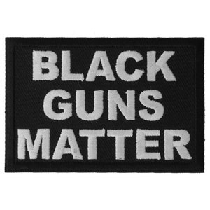 May include: Black and white embroidered patch with the text "Black Guns Matter" on a black background.