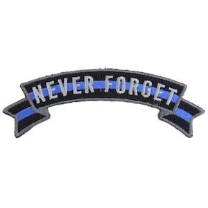 May include: Black and gray embroidered patch with a blue line and the text "NEVER FORGET" on a curved banner.