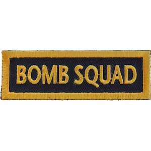 May include: A black embroidered patch with a yellow border. The patch says "BOMB SQUAD" in yellow lettering.