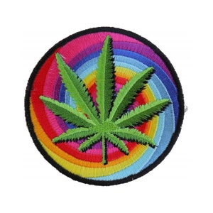 May include: A green marijuana leaf embroidered on a round patch with a rainbow swirl pattern.