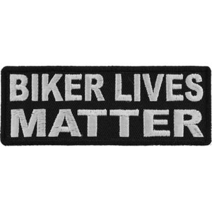 May include: Black rectangular patch with white embroidered text that reads "BIKER LIVES MATTER". The patch is likely designed to be sewn or ironed onto clothing or accessories, such as a jacket or vest.