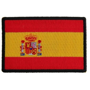 May include: A red and yellow embroidered patch with the coat of arms of Spain in the center. The patch has a black border.