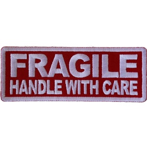 May include: Red rectangular fabric patch with white embroidered text that reads "FRAGILE HANDLE WITH CARE".