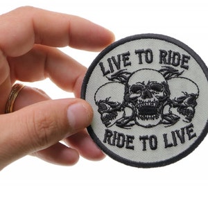 May include: A white and black embroidered patch with three skulls and the text "Live to Ride, Ride to Live".