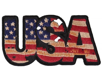 May include: A red, white, and blue embroidered patch with the word "USA" in large, bold letters. The letters are outlined in black and filled with the American flag design.