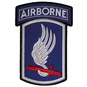 May include: A blue and white embroidered patch with the word "AIRBORNE" in white lettering on a blue background. The patch features a white stylized wing with a red dagger.