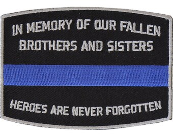 May include: Black embroidered patch with a thin blue stripe in the center. The text reads "In Memory of Our Fallen Brothers and Sisters Heroes Are Never Forgotten."